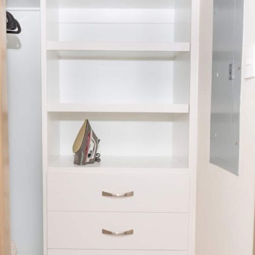 Built-in shelving unit with drawers, open shelves and iron for convenient storage