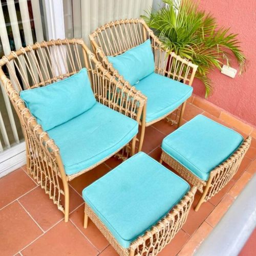 Outdoor balcony seating with rattan chairs and turquoise cushions, matching ottomans and tropical plant