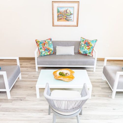 Cozy seating area with grey sofa set, tropical print cushions and coffee table